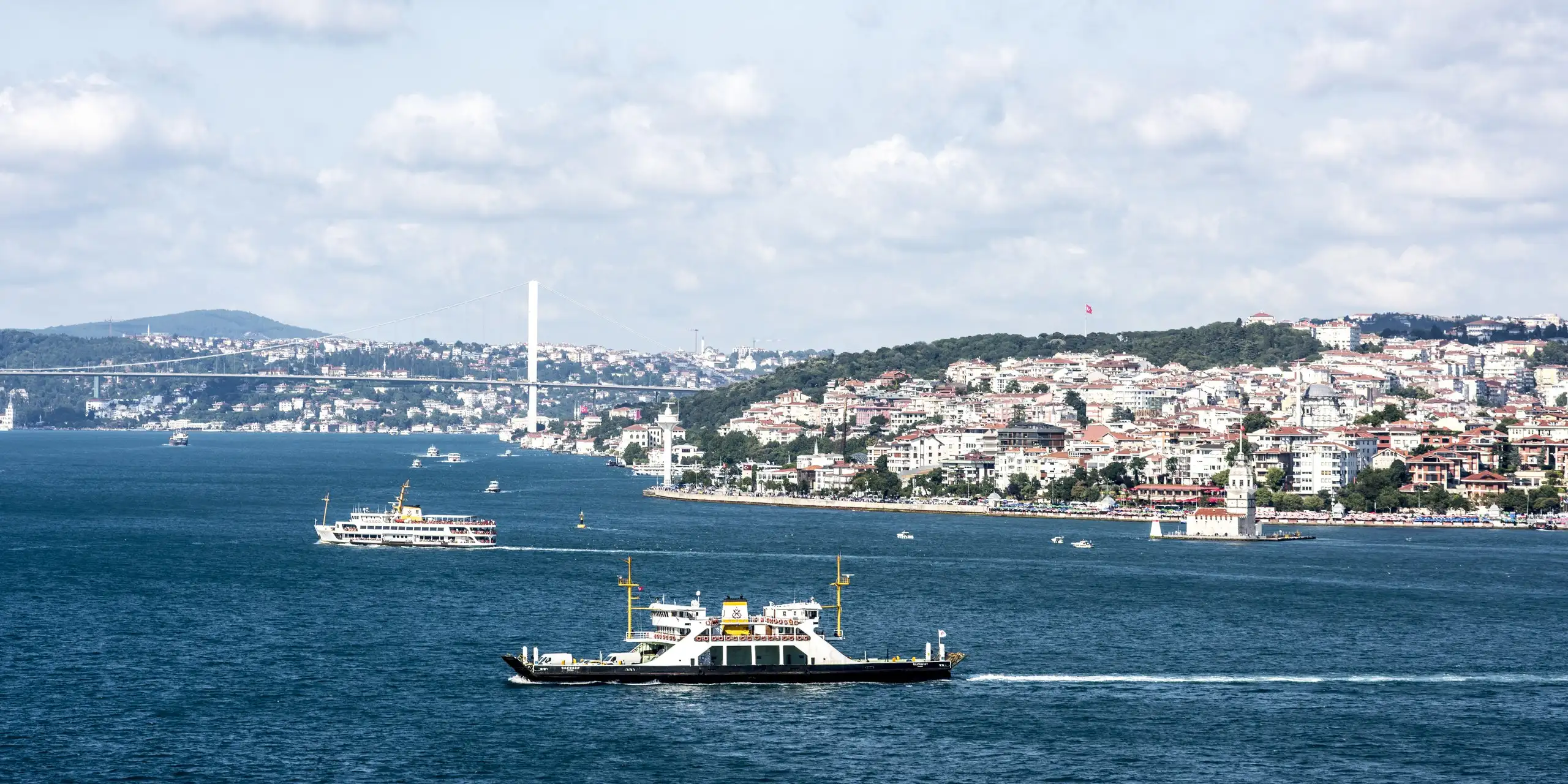 Ferries crossing the Bosphorus in Istanbul, with the Maiden’s Tower and the Üsküdar shore behind them